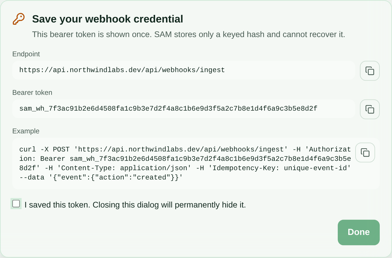 Save your webhook credential dialog showing the ingest endpoint URL, a one-time sam_wh_ bearer token, a curl example with an Idempotency-Key header, and an I saved this token checkbox